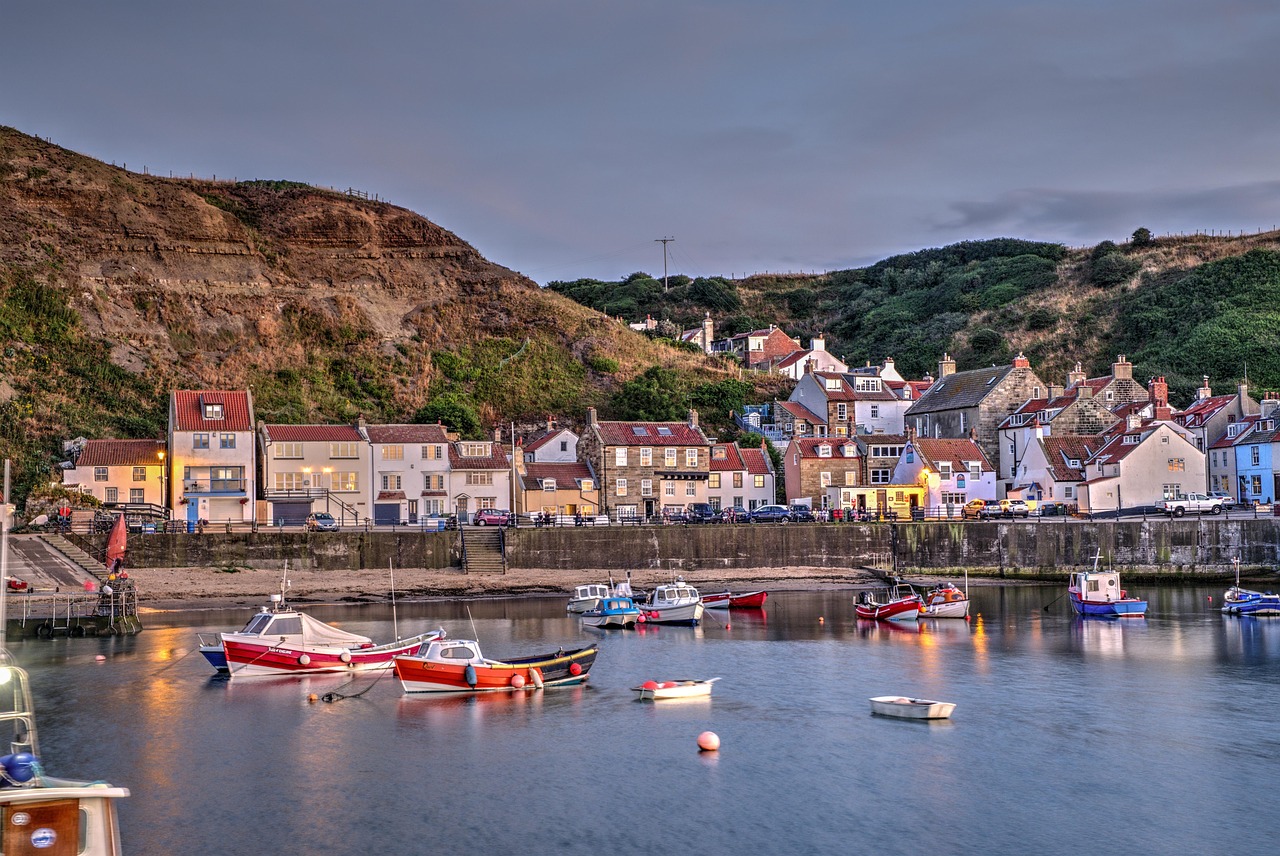Fishing boats in Staithes harbour below hillside cottages on the North Yorkshire coast